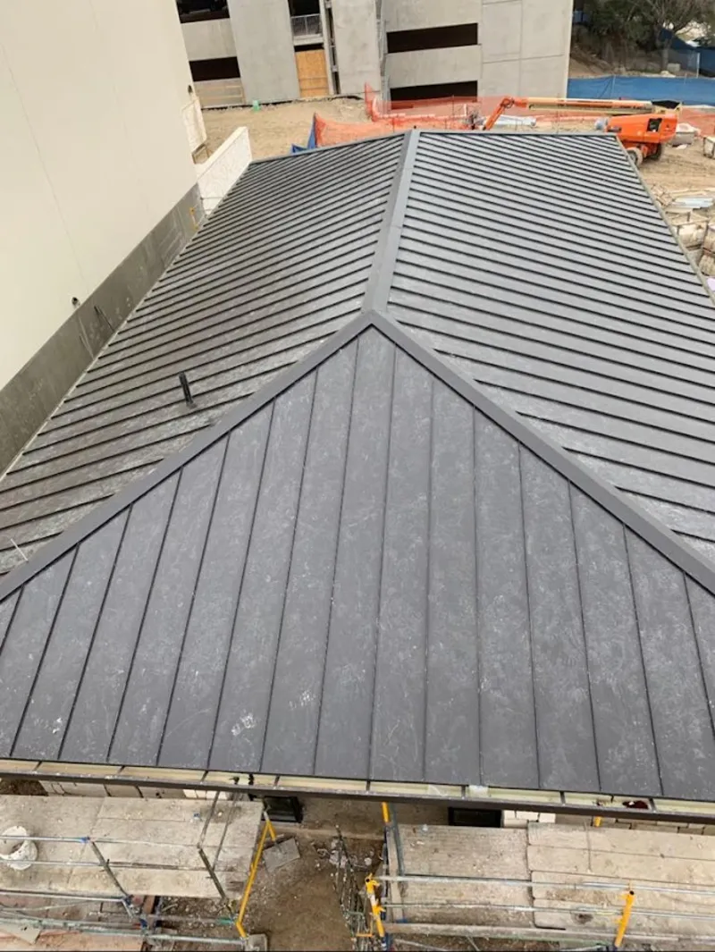 Commercial metal roof construction with crane equipment in Mebane